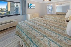 a hotel room with two beds and a window at 1BR Direct Oceanfront Views at Palms - Nice Pools! in Myrtle Beach