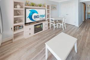 a living room with a tv and a table at 1BR Direct Oceanfront Views at Palms - Nice Pools! in Myrtle Beach