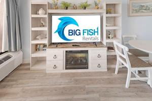 a living room with a big fish rentals sign on a tv at 1BR Direct Oceanfront Views at Palms - Nice Pools! in Myrtle Beach +38 photos