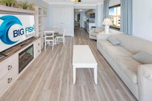 a living room with a couch and a tv at 1BR Direct Oceanfront Views at Palms - Nice Pools! in Myrtle Beach
