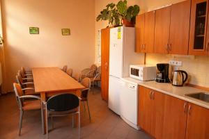 a kitchen with a table and a white refrigerator at REVIS Tachov in Tachov