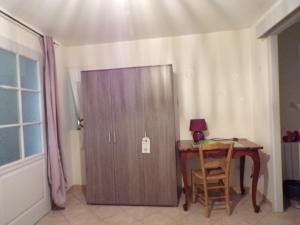 a wooden door next to a table and a desk with a lamp at La Grange in Dieulivol