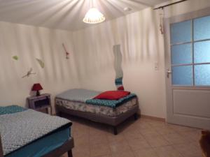 a room with two beds and a window at La Grange in Dieulivol
