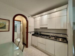 a kitchen with white cabinets and a sink at Villa Luciana in Grado