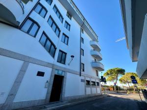 a white building with a door in a street at Villa Luciana in Grado +3 photos