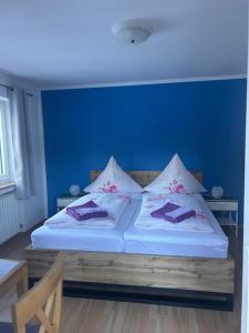 a blue bedroom with a bed with two pillows at Gästehaus Lehnerer Grainau in Grainau +11 photos
