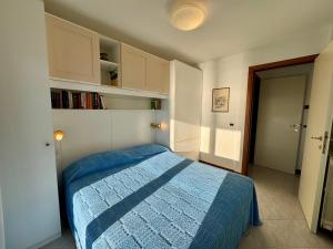 a bedroom with a bed with a blue comforter at Villa Luciana in Grado