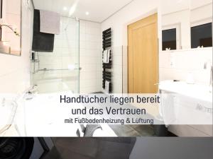 a bathroom with a glass shower and a sink at Ferienhaus Däschinger in Mastershausen +74 photos