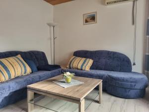 a living room with blue couches and a coffee table at Königsfeld in Königsfeld