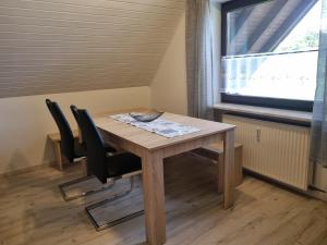 a table and chairs in a room with a window at Königsfeld in Königsfeld