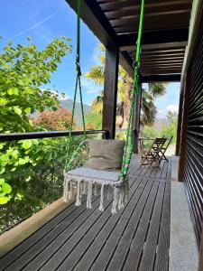 a swinging chair on a porch with a view at Pousada RIO CALDO in Rio Caldo