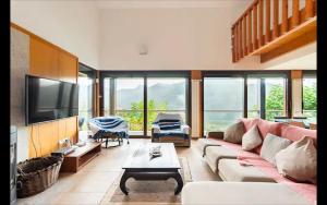 a living room with a couch and a tv at Pousada RIO CALDO in Rio Caldo