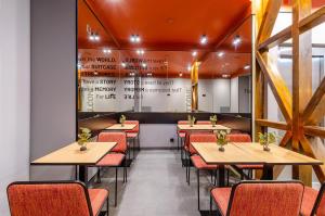 ein Restaurant mit Holztischen und roten Stühlen in der Unterkunft LX Arch Hotel in Lissabon