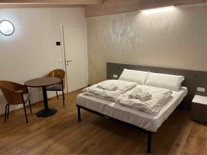 a bedroom with a bed and a table and a table at Respiro di lago in Molveno
