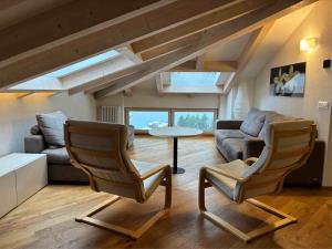 a living room with two chairs and a table at Respiro di lago in Molveno