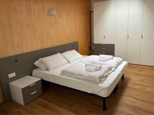 a bedroom with a bed with white sheets and pillows at Respiro di lago in Molveno