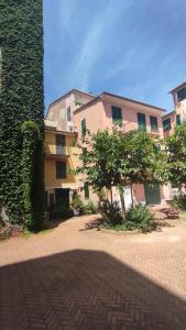 a building with a tree next to a brick road at DIMORA della TORRE a due passi dal mare in Sestri Levante