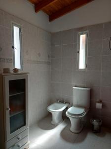 a bathroom with a toilet and a sink and window at Brisa Costera Studio in Carmen de Patagones