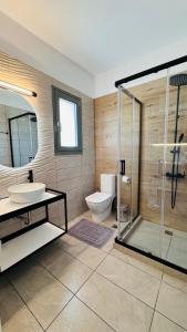 a bathroom with a toilet and a sink and a shower at Aroniadika rooms in Kythira +41 photos