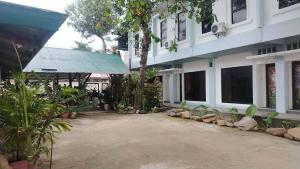 a building with a courtyard in front of it at La Bottega Pension House in Roxas