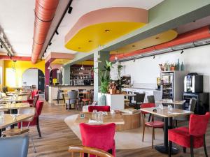 a restaurant with tables and chairs and a cafeteria at greet Hotel Massieux Lyon Nord by All Accor in Massieux