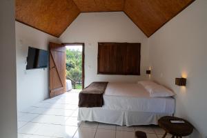 a bedroom with a bed and a flat screen tv at Tekoha Eco Hotel in Bonito