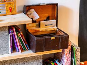a suitcase sitting on a shelf with books at greet Hotel Massieux Lyon Nord by All Accor in Massieux