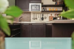 a kitchen with brown cabinets and a microwave at Villa Monica in Le Bolle