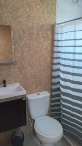 a bathroom with a white toilet and a sink at El Refugio in Santa Vitória do Palmar