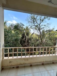 a balcony with a view of trees and bushes at Chetanya Homestay in Puttaparthi
