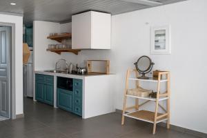 a kitchen with green cabinets and a white wall at Keresbino Hydra Port House in Hydra
