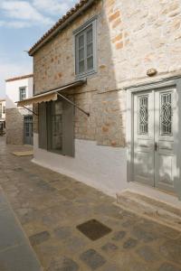 a brick building with a door and a window at Keresbino Hydra Port House in Hydra