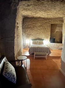 a bedroom with a bed in a stone wall at AIRE Vejer - recién reformado 2026 in Vejer de la Frontera