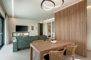 a living room with a wooden table and a green couch at Deux Olives Luxury Villa in Maleme