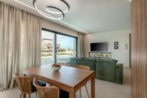 a dining room with a table and a couch at Deux Olives Luxury Villa in Maleme