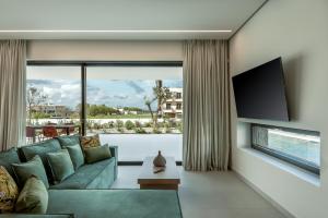 a living room with a couch and a large window at Deux Olives Luxury Villa in Maleme