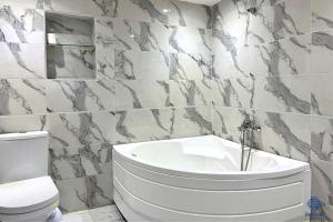 a bathroom with a white tub and a toilet at Perlivia in Chefchaouen +10 photos