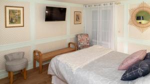a bedroom with a bed and a chair and a tv at Gite le Mont Blanc in Le Mesnil-sur-Oger