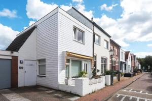 a white house on the side of a street at Zaras Studio Hermes in Zandvoort
