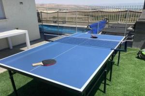 a ping pong table with a ping paddle on it at וילה קלמה מגדל in Migdal +1 photo