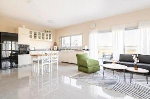 a kitchen and living room with a couch and a table at וילה קלמה מגדל in Migdal