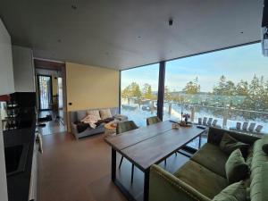 a living room with a table and a large window at Modern Cabin At Blefjell in Svene
