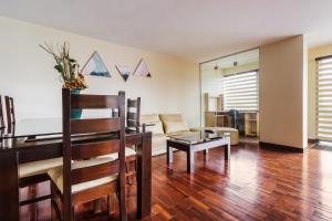a living room with a table and a couch at Luxstone Executive & Suites in La Paz