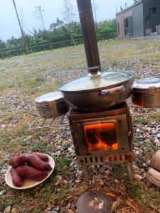 a grill with a pot and a plate of food at 陌野輕旅民宿 in Xiulin