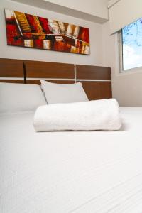 a bedroom with two white beds and a painting on the wall at Hotel Benidorm Panama in Panama City +21 photos