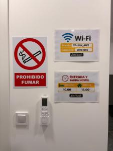 a door with signs on it with a cell phone at LITTLE Hostel in Puerto de Sagunto