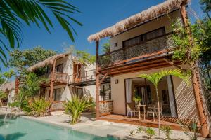 a house with a swimming pool in front of it at Villas AHAL, in Chemuyil