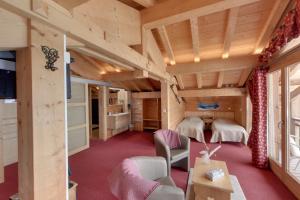 a large room with red carpet and wooden ceilings at Hôtel L'Accroche Coeur in La Rosière