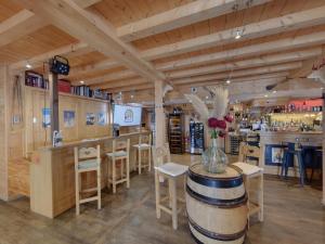 a bar with a table and chairs and a barrel at Hôtel L'Accroche Coeur in La Rosière