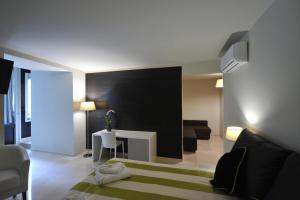 Sala de estar con cama, sofá y mesa en Gatto Bianco House, en Bari